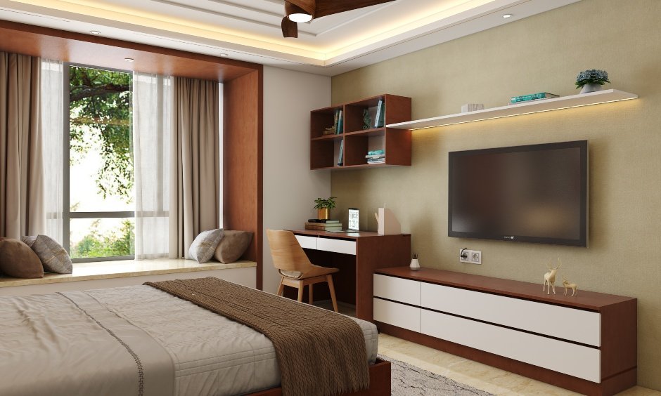 The bedroom tv unit design has an attached study table with open shelf units
