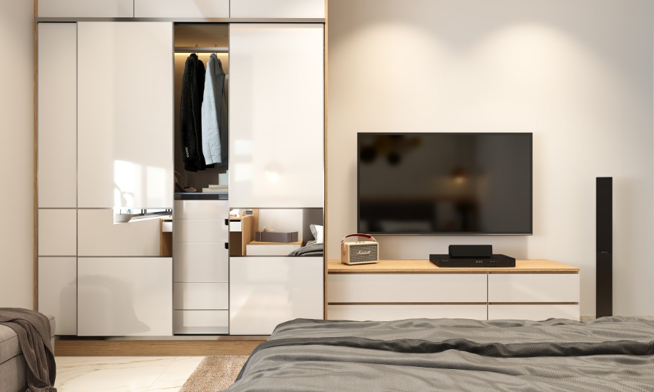 Bedroom sliding wardrobe in 1 bhk interior designed with attached tv unit is a perfect example of multifunctional