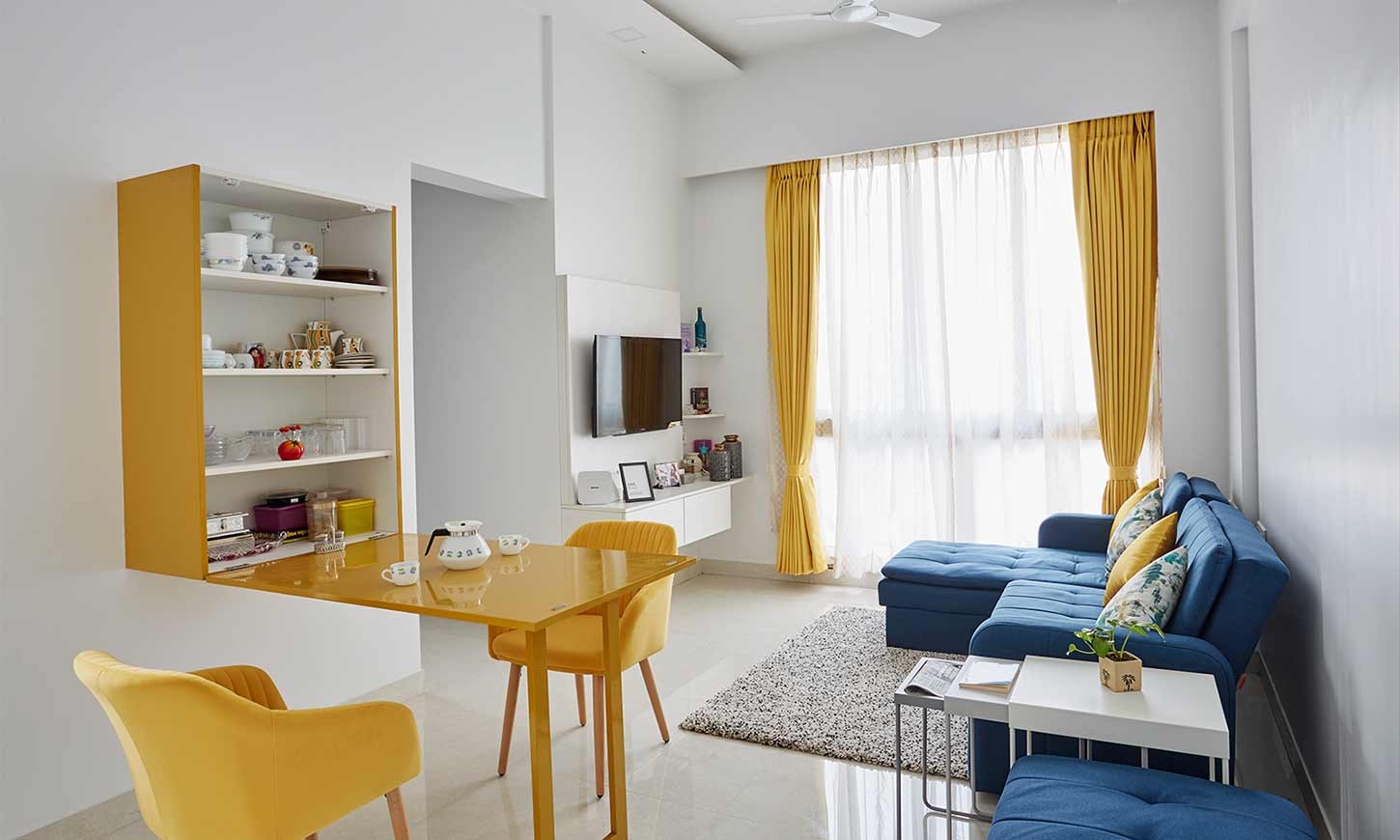 Interior decorators in mumbai for living room with a folding dining table with hidden crockery unit inside