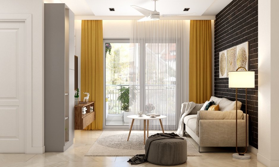 Interior design company in chennai where the brick cladding accent wall on the living room cuts the monotony of pastel colours
