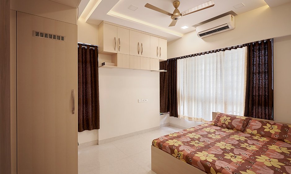 Bedroom with overhead cabinet storage designed by designcafe